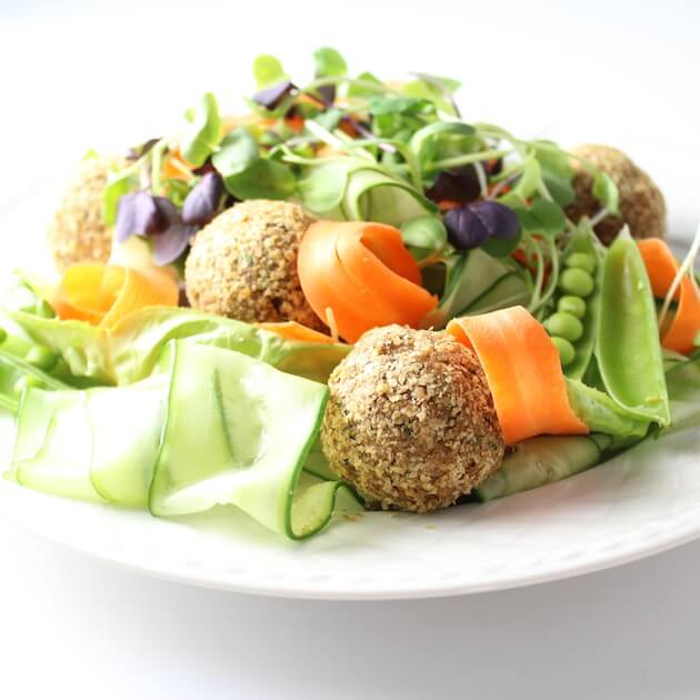 Eye level plate full of bright fresh vegetables with Vegetarian Meatballs 