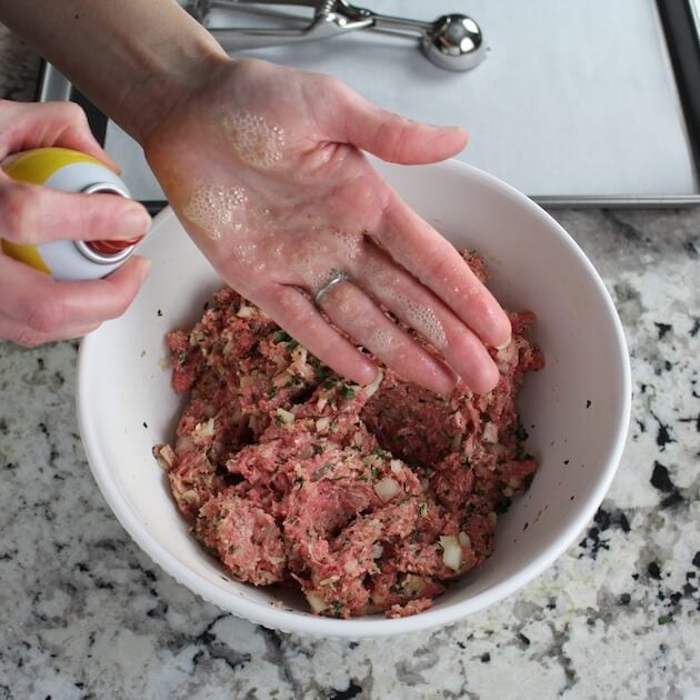 Spraying hands to handle meatballs
