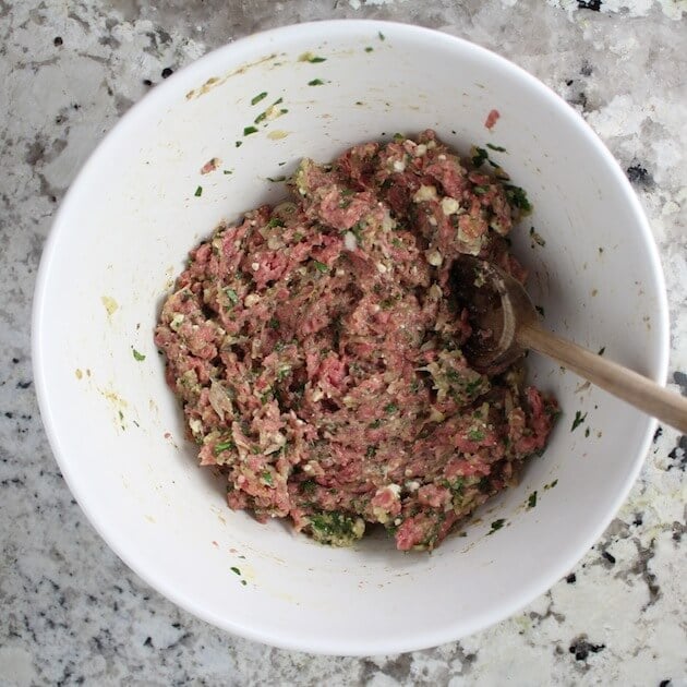 Meatball ingredients mixed together in large white bolw