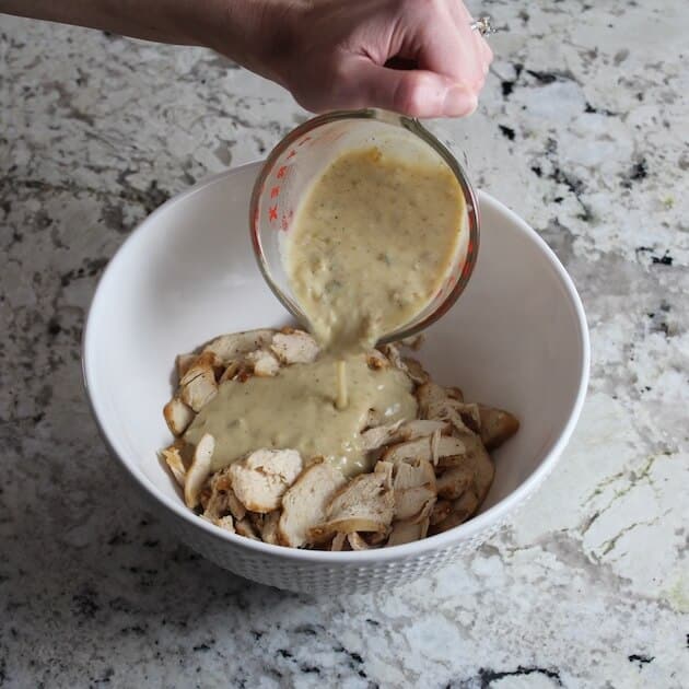 Adding Cheese sauce into mixing bowl with sliced chicken