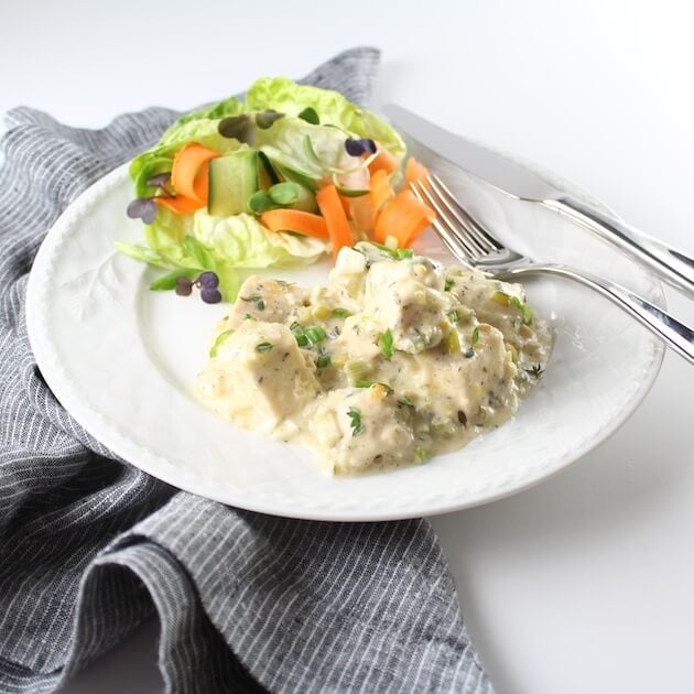 White plate of Cheesy Hot Chicken Salad with side of veggies