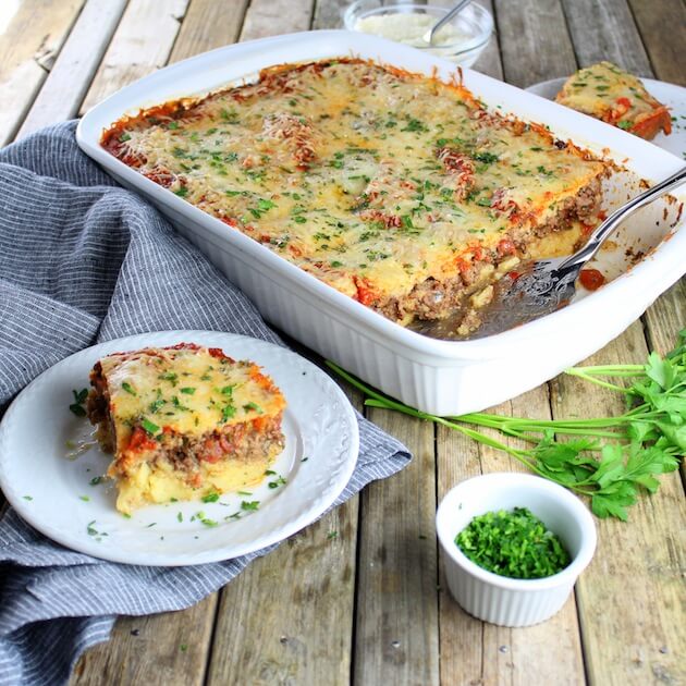 Casserole dish with Lamb Lasagna on farm table