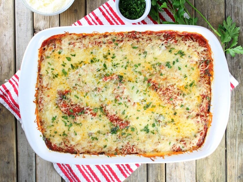 Lamb Lasagna With Parmesan Polenta in white casserole dish on farm table