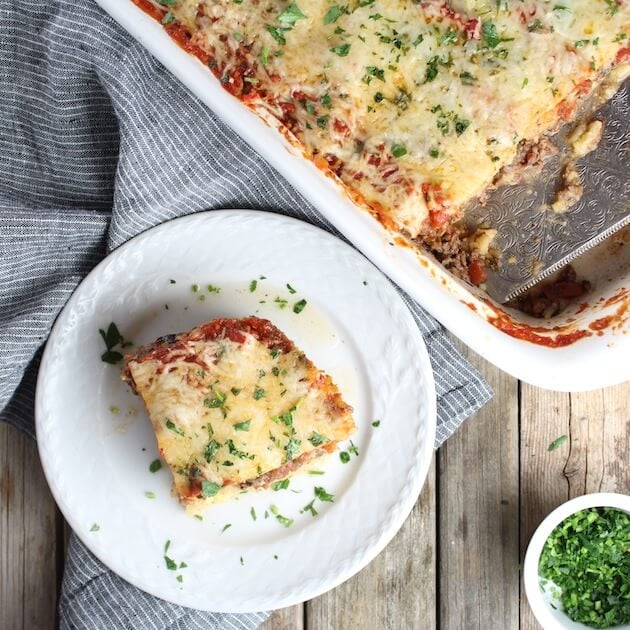 Piece of Lamb Lasagna on a plate next to full casserole dish