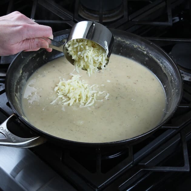 Adding shredded cheese to saute pan