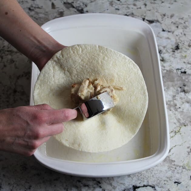 Adding chicken enchilada filling to tortilla