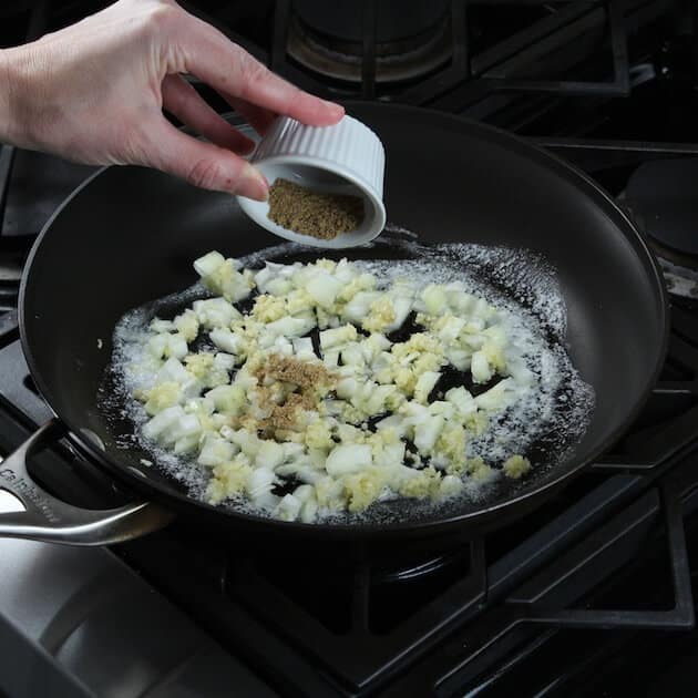 Adding cumin to onions and garlic in sautee pan