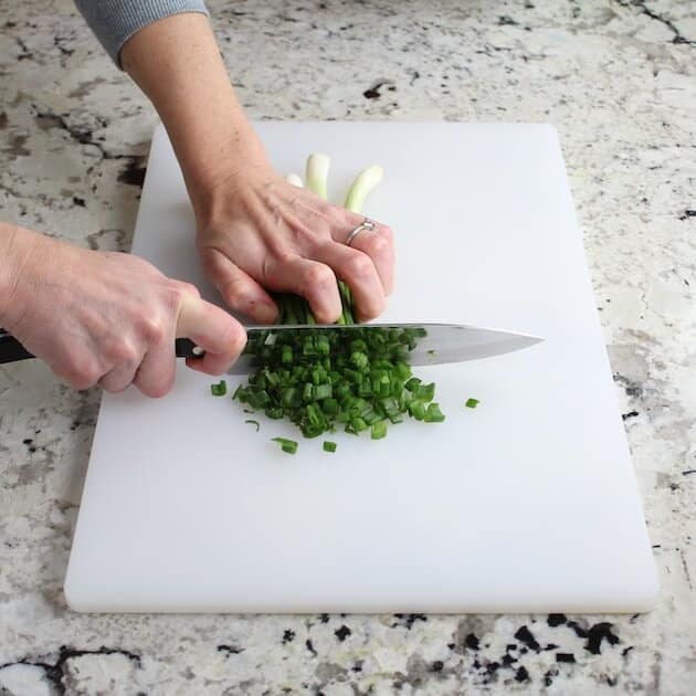 cutting up green onions on cutting board