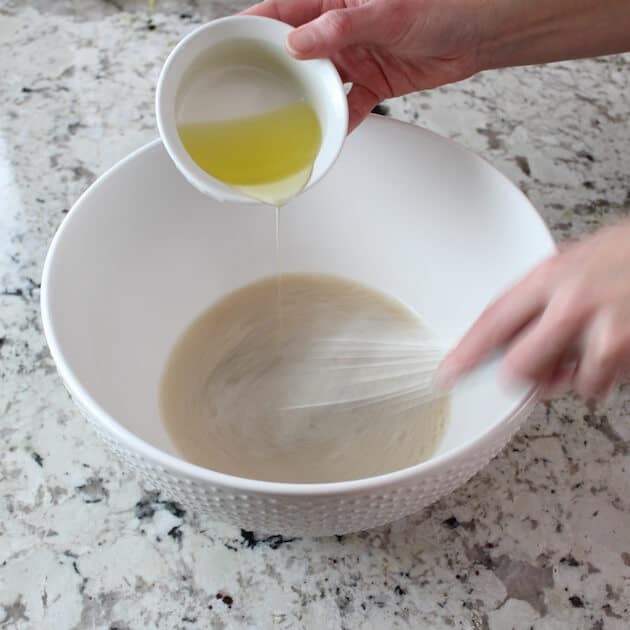 Adding oil to yeast in mixing bowl