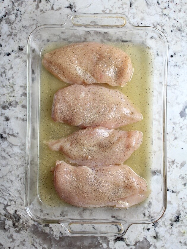 chicken breasts with salt &amp; pepper in a baking dish ready to cook