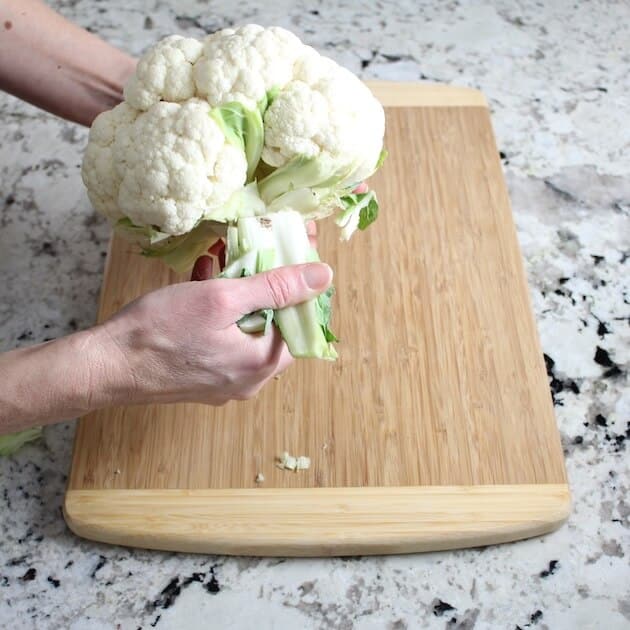 Remove leaves from head of cauliflower