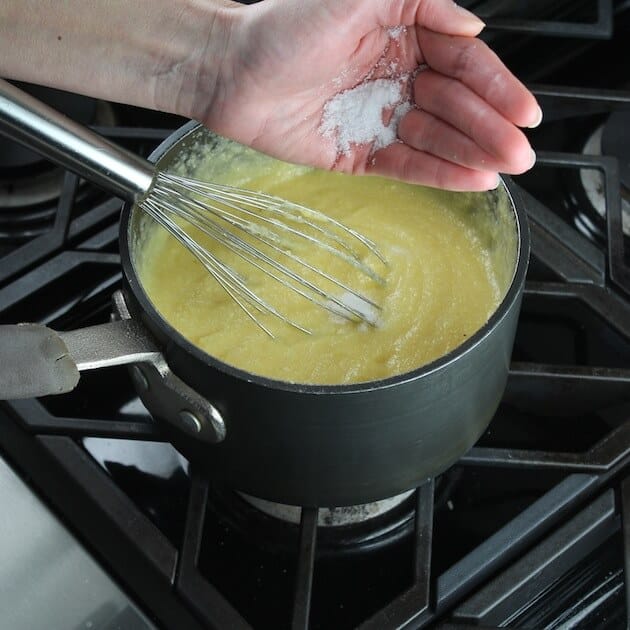 Adding salt to polenta on stovetop