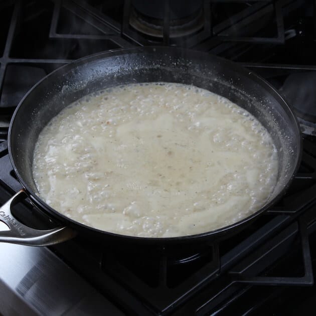 A pan of food on a stove, with Enchilada and Cheese