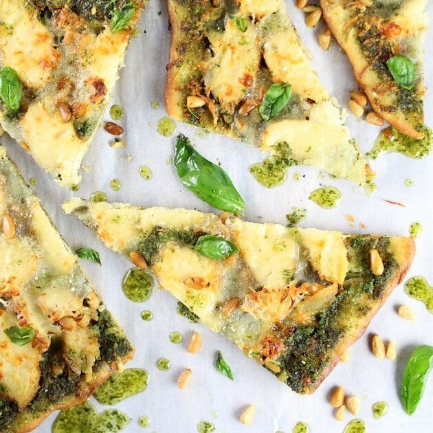 Slices of chicken pesto pizza on parchment paper