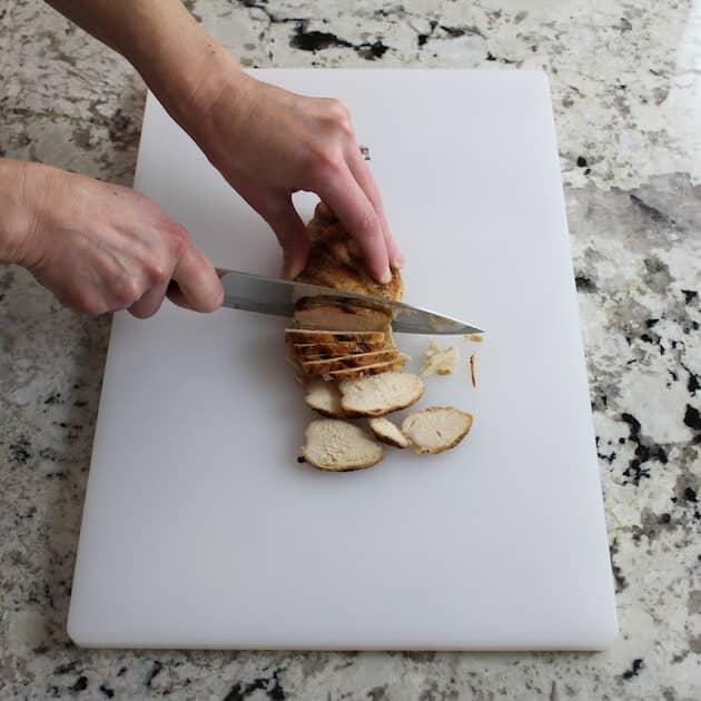 slicing chicken on cutting board