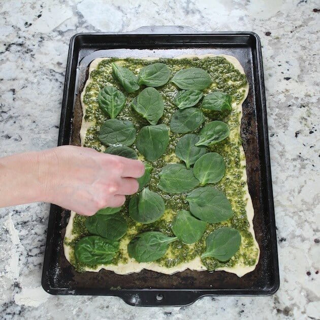 Adding spinach to Chicken Pesto Pizza