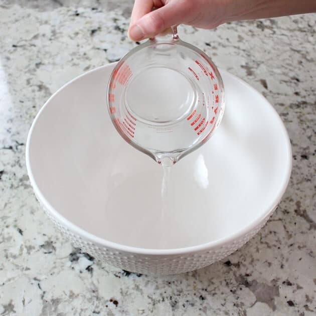 Pouring water into empty mixing bowl