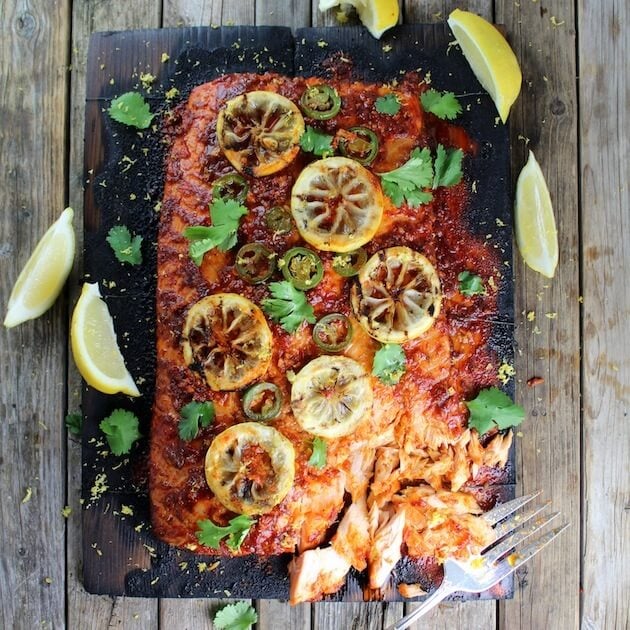 Very large side of salmon with lemon garnish on cedar plank after smoking 