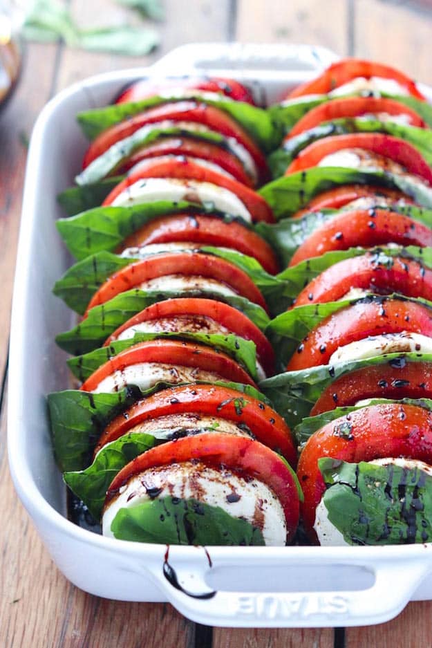 Rows of sliced tomatoes and fresh mozzarella with basil and balsamic