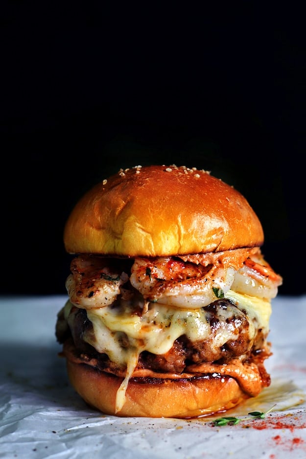 Huge cheeseburger with chorizo and shrimp on parchment paper