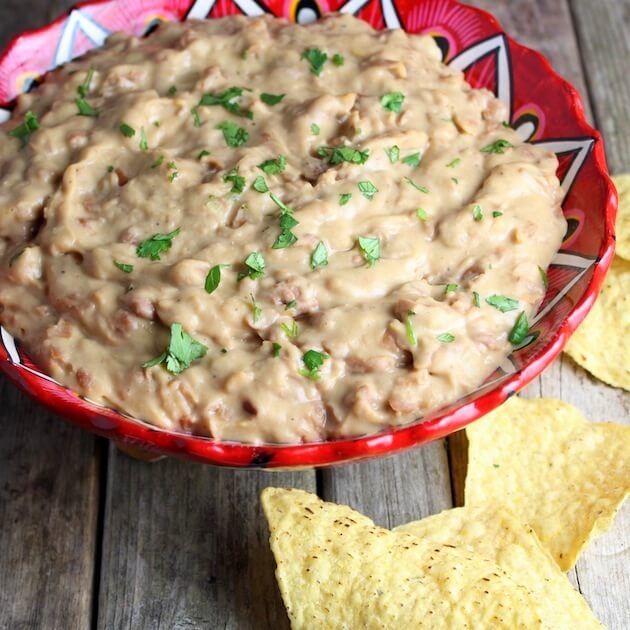 Homemade Refried Beans in festive mexican pottery bowl with corn chips