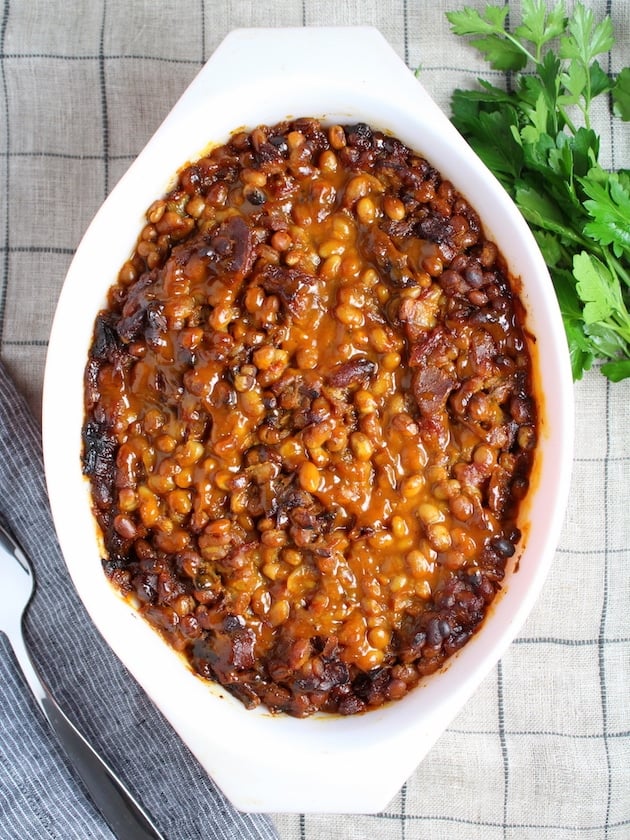 BBQ Baked Beans in a serving dish with parsley garnish