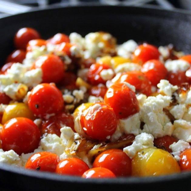 Crumbled feta on Cherry Tomatoes in a skillet 