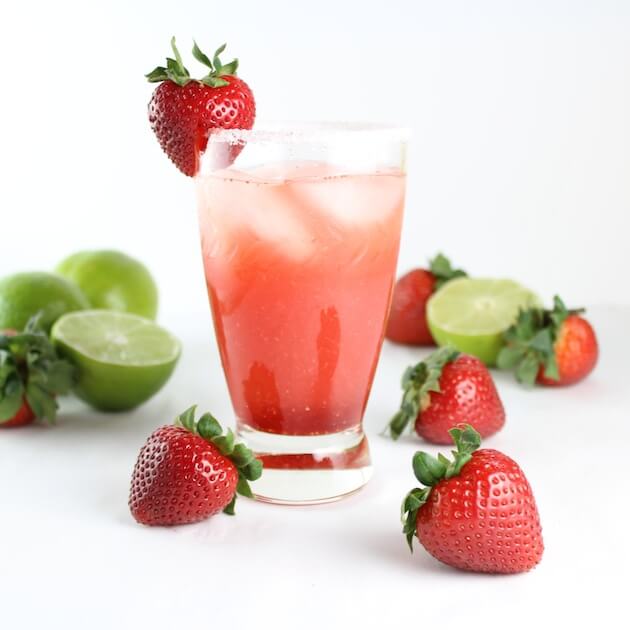 Fresh Strawberry Margarita in a glass with limes and strawberries