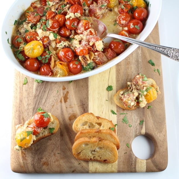 Sweet Cherry Tomatoes with French Feta in dish on cutting board with crostini