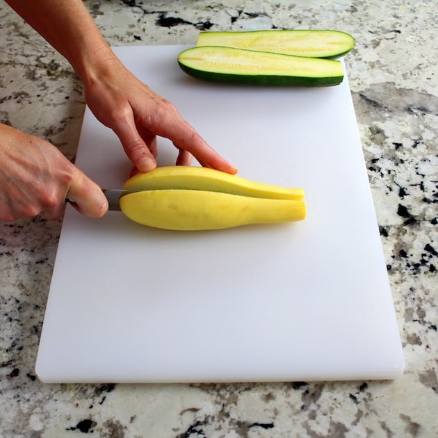 Slicing yellow squash on cutting board