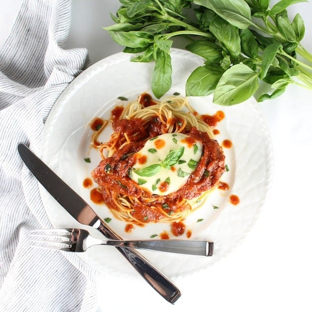 Dinner plate with Italian Baked Chicken breast on spaghetti pasta