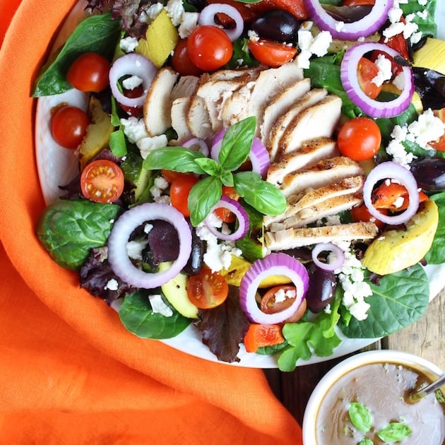 Grilled Mediterranean Chicken Salad on plate with orange napkin