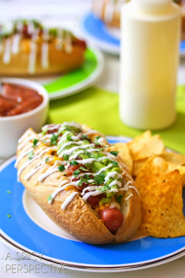 Hot Dog on a plate next to nacho cheese corn chips