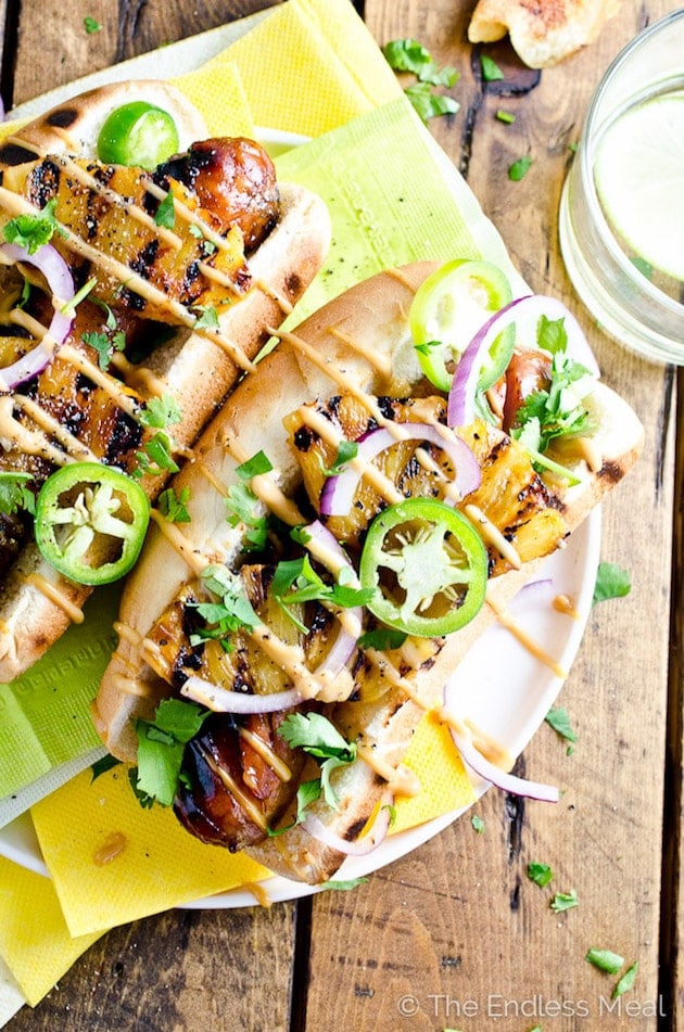 Hawaiin-Hot-Dogs-with-Grilled-Pineapple-and-Teriyaki-Mayo on yellow napkins with jalapenos