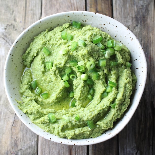Spicy Green Hummus in a bowl on farm table
