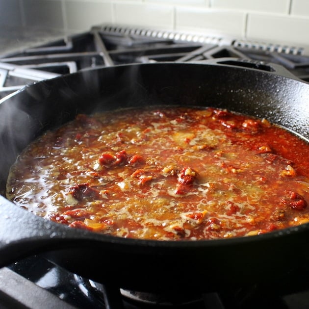 Red liquid steaming in skillet on stovetop