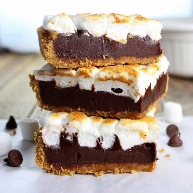 Stack of three Baked Nutella S\'mores brownies with graham cracker crust, nutella center, and toasted marshmallows on top