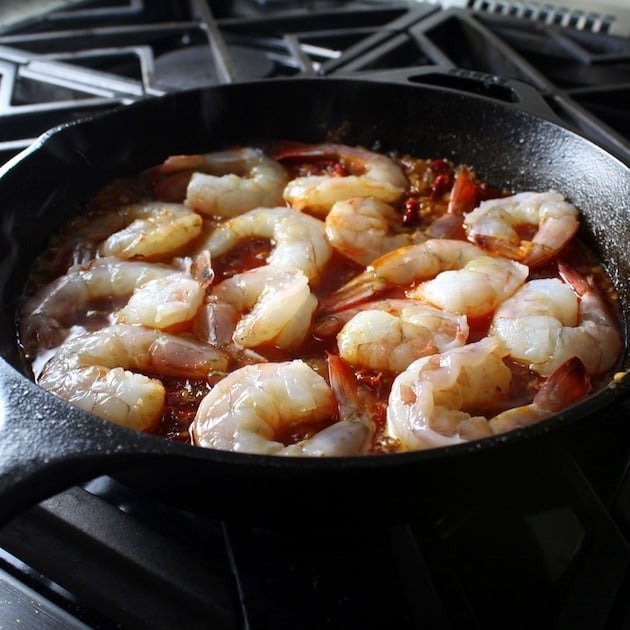 Shrimp in sautee pan with red sauce on stovetop