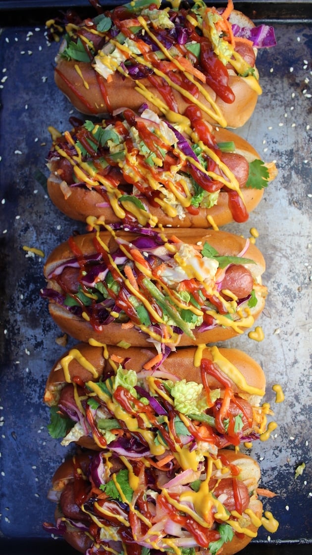 These Korean Slaw Dogs are an amazing game-day favorite! all-beef hot dogs loaded with Korean BBQ sauces, spicy kimchi, & sweet/tangy slaw, topped w/kickin' ketchup & mustard. Asian fusion in a bun! #hotdogs #kimchi #slaw https://tasteandsee.com
