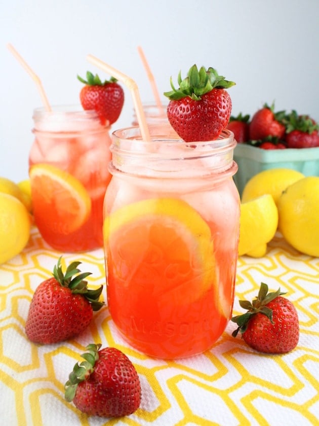 Red strawberry drink with ice cubes in mason jars