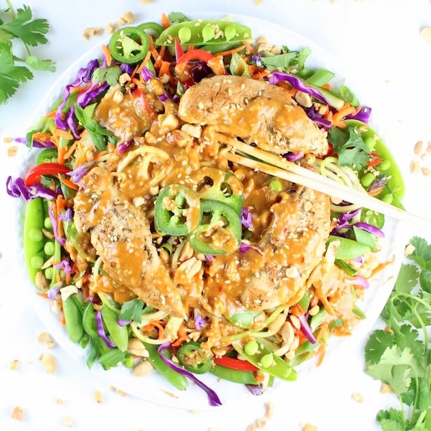 Bright fresh salad with chicken tenders, peanut sauce, and chopsticks 