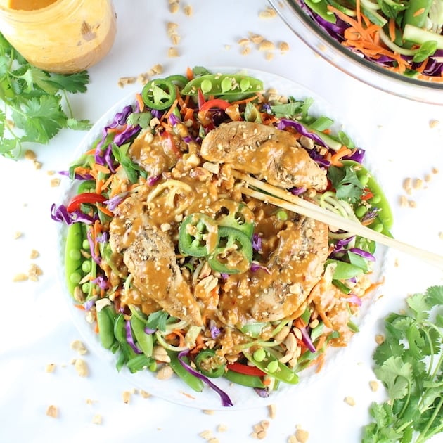 Chicken Satay Zoodle Salad with peanut sauce and bowl of slaw