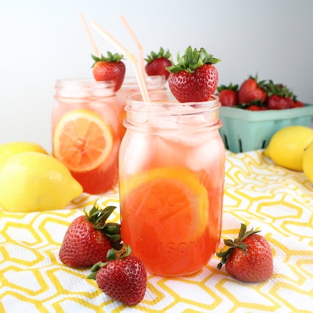 Strawberry Lemonade cocktails in mason jars with fresh strawberries and lemons