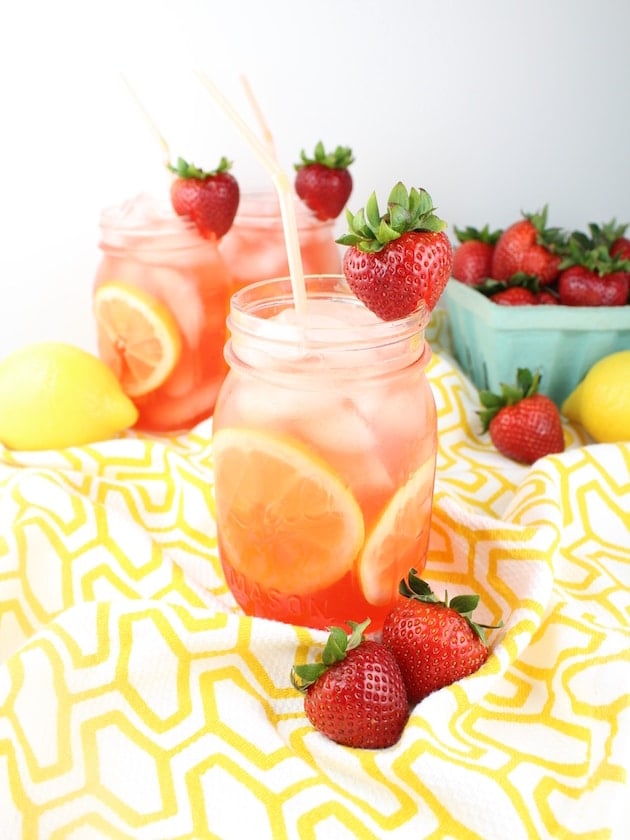 Loaded Strawberry Lemonade in mason jars on a yellow patterned tablecloth