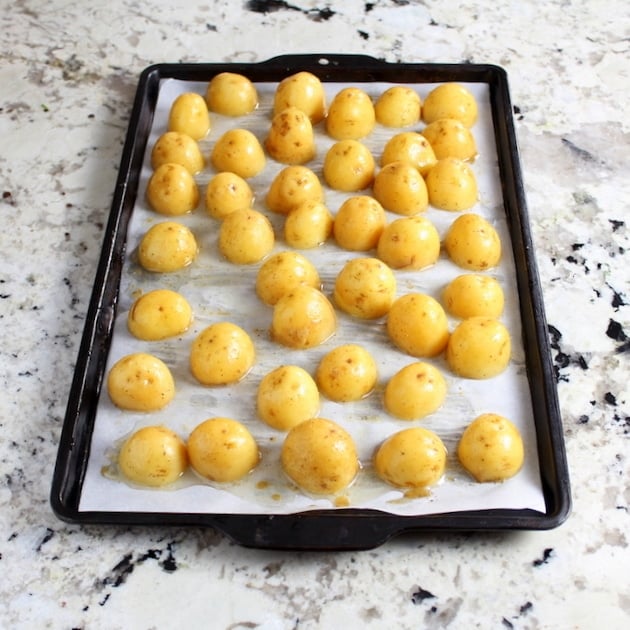 Potatoes ready to bake on cookie sheet