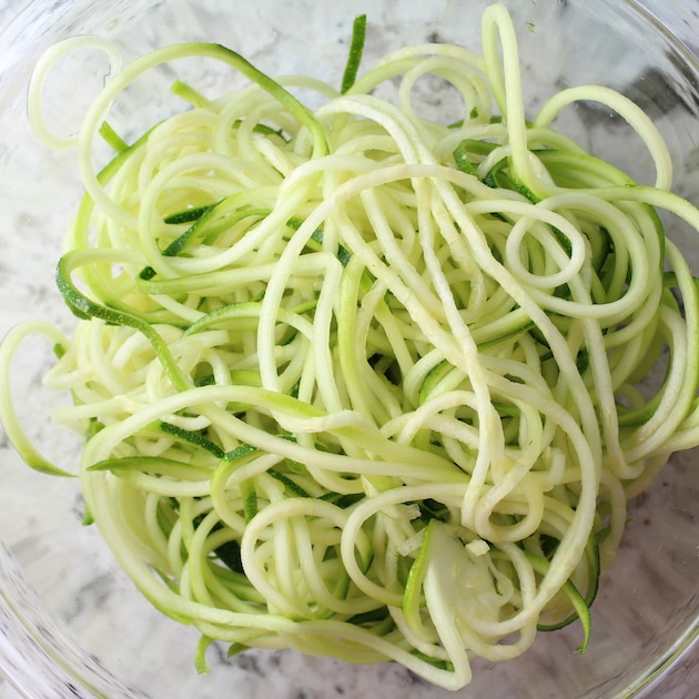 Zucchini Noodles in glass bowl on granite counter
