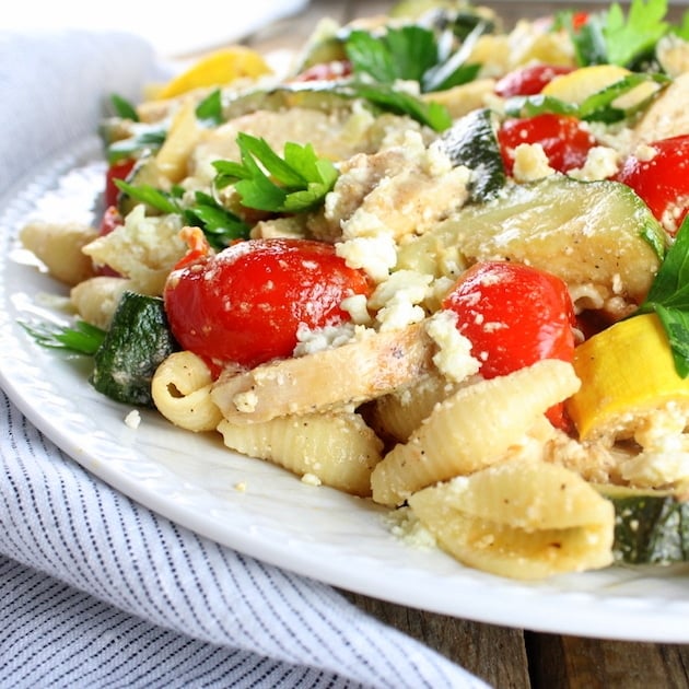 Eye level partial platter of pasta, tomatoes, and zucchini