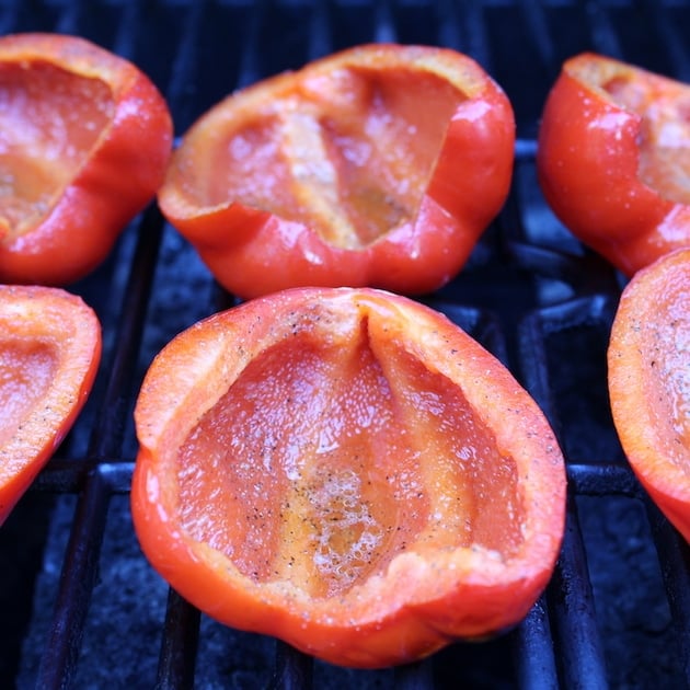 Halved red bell peppers on the grill