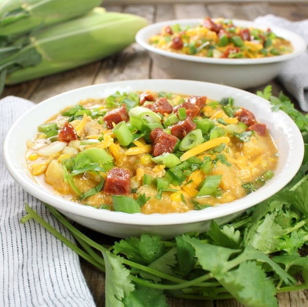 Two bowls of corn chowder on a farm table