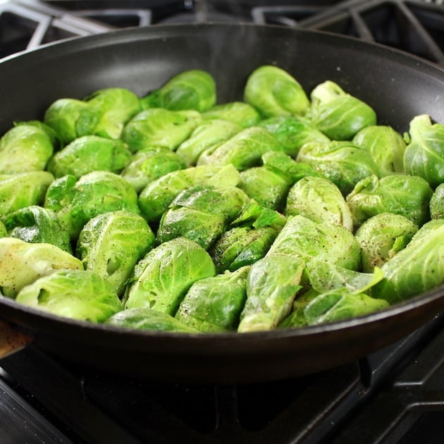 Bright green brussels sprouts uncooked in a saute pan